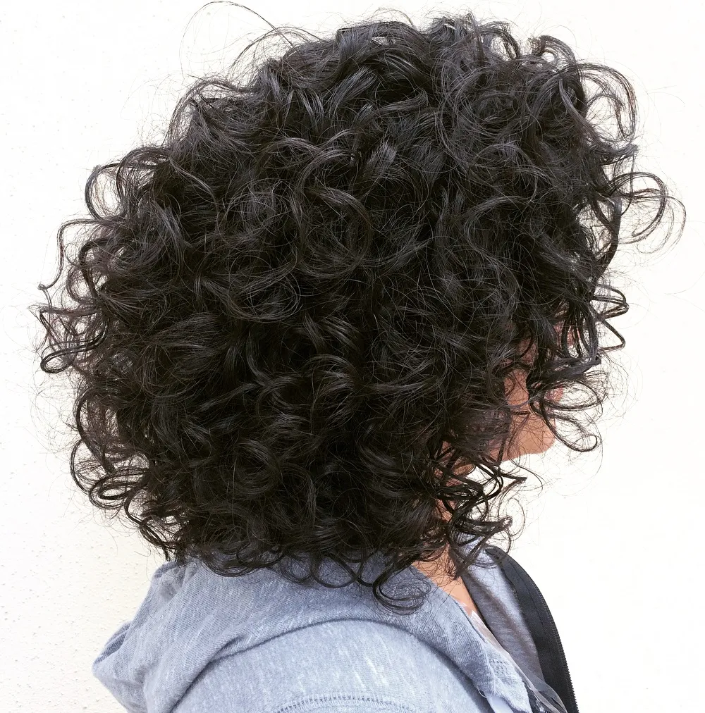 Femme avec un chignon twist français décoiffé, style élégant et décontracté.